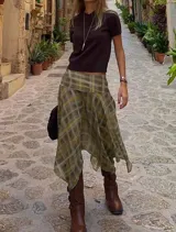 Pollera midi de diseño asimétrico con caída fluida y terminación en puntas. Presenta un estampado cuadrillé en tonos verde oliva, mostaza y beige, con cintura alta y calce cómodo.