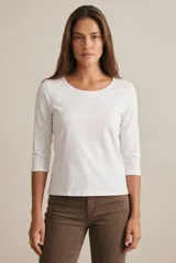 Remera de algodón con elastano, de corte ajustado al cuerpo, con escote redondo y mangas tres cuartos.