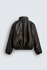 Cazadora de corte relajado confeccionada en tejido efecto piel con acabado lavado. Presenta cuello subido, cierre frontal de cremallera, mangas largas con puños elásticos y ruedo elástico. Incluye bolsillos laterales y un bolsillo interior.