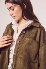Sobrecamisa de gamuza sintética en color marrón chocolate, con corte oversize, cuello camisero, cierre frontal con botones y bolsillos frontales tipo parche.