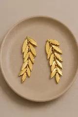 Aros colgantes dorados con diseño de rama de olivo compuesto por múltiples hojas articuladas.