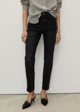 Jeans mom fit de tiro alto y corte recto, confeccionados en denim negro con tejido elástico. Cuentan con diseño clásico de cinco bolsillos, trabillas para cinturón y cierre frontal con cremallera y botón metálico.