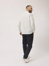 Camisa de hombre de manga larga con rayas verticales en tonos verde claro y blanco. Confeccionada en una mezcla de lino y algodón, presenta cuello abotonado y bolsillo en el pecho.