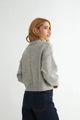 Cardigan de punto color marrón chocolate, con cuello redondo, cierre frontal de botones y diseño de costuras verticales visibles. Presenta puños y ruedo acanalados.