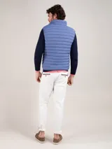 Chaleco acolchado de hombre color celeste, confeccionado en nylon reciclado con diseño matelasse, cuello alto y cierre frontal de cremallera.