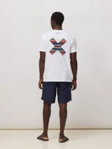 Remera de algodón orgánico color blanco, con corte regular fit y detalle de bordado en forma de X con diseño geométrico multicolor en el pecho.