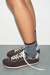 Zapatillas de estilo deportivo con diseño barefoot, confeccionadas en una combinación de materiales que incluye piel vacuno en la lengüeta. Presentan una puntera amplia, suela flexible con efecto engomado, plantilla Ortholite extraíble y cierre mediante cordones.