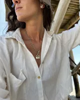 Collar de cadena de eslabones alargados con cierre frontal tipo T y dije circular de textura rústica e irregular.