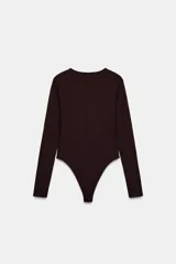 Body de manga larga confeccionado en mezcla de poliamida, con cuello redondo y cierre inferior con botones a presión.