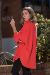 Camisa roja de polar, corte oversize, con cuello camisero, cierre frontal con botones a presión, mangas largas con puños abotonados, bolsillos de parche en el pecho y ruedo redondeado.