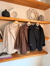 Blazer de corte entallado color marrón, con solapas clásicas y mangas largas con puños vueltos.