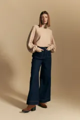 Sweater color crema con mangas abullonadas y puños elastizados. Presenta una textura tejida en relieve con patrón de ladrillos en el cuerpo y rayas horizontales en las mangas.