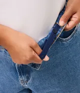 Pantalón mom jeans de tiro alto con lavado efecto mármol, corte holgado en cadera y piernas con ruedo ajustado. Cuenta con trabillas en la cintura, bolsillos funcionales y cierre frontal con botón.