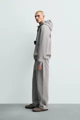 Pantalón jogger de corte regular fit y color negro, confeccionado en tejido compacto de algodón con interior de rizo. Cuenta con cintura elástica, bolsillos frontales y un bolsillo trasero de doble vivo.
