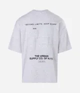 Remera gris melange de corte relaxed, con cuello redondo y mangas cortas. Presenta un diseño gráfico en la espalda con estampado y textura en alto relieve embossed que incluye la frase "Beyond Limits: Keep Going" y el texto "The Urban Supply Co. of N.Y.C.".