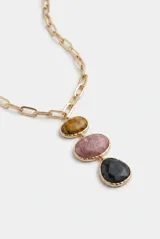 Collar largo de cadena eslabonada metálica dorada con un colgante compuesto por tres piezas de resina en tonos marrón, rosado y gris oscuro.