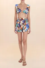 Short de playa con estampado botánico en tonos blanco, azul, verde y marrón. Presenta cintura elástica fruncida y corte estructurado con pliegues frontales.