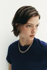 Jersey de punto de cuello redondo y manga corta, con diseño minimalista y textura suave.