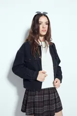 Campera de jean color negro con cuello de pana en tono marrón, cierre frontal con botones y bolsillos en el pecho. Presenta un diseño de corte relajado y ligeramente cropped, con interior forrado en corderito para mayor abrigo.