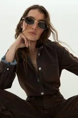 Sobrecamisa de jean efecto terciopelo color marrón con costuras visibles y botones metálicos a presión. Presenta bolsillos frontales con solapa y mangas largas con puños abotonados.