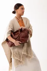 Cartera tipo shopper de cuero genuino color habano, con diseño estructurado, hebillas laterales decorativas y doble bolsillo frontal. Incluye colgante interno para llaves.