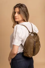 Cartera mochila versátil de cuero sintético con textura granulada, color negro. Cuenta con múltiples bolsillos frontales con cierre, correas ajustables que permiten su uso tanto como cartera de hombro o como mochila, y herrajes metálicos.