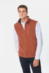 Chaleco deportivo rojo de polar con forro e interior en color azul combinado, cierre frontal y bolsillos delanteros con cierre metálico personalizado. Incluye dos bolsillos interiores con cierre y logo bordado en el pecho.