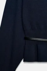 Jersey de punto color mostaza con cuello barco, manga larga con sisa ancha y detalle de cinturón fino integrado en la cintura.
