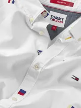 Camisa blanca de popelina de puro algodón con estampado de banderas náuticas y logos de Tommy Jeans bordados. Corte clásico, cuello abotonado, puños con botón y bajo redondeado.