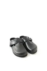 Mocasines negros con hebilla y suela gruesa.