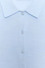 Chaqueta de punto celeste, de manga corta, con cuello solapa y cierre frontal con botones.