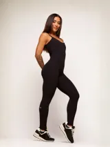 Jumpsuit deportivo de una pieza color negro, con breteles finos, espalda escotada y diseño ajustado al cuerpo. Confeccionado en poliamida de alta performance, cuenta con un recorte estratégico con efecto levanta glúteos.