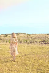 Vestido color beige con estampado de hojas, corte recto, largo midi y ajuste en la cintura con cordón.