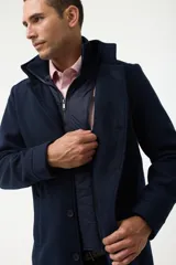 Gabán azul marino con cuello alto y pechera desmontable con cierre.