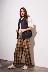 Chaleco oversize de denim negro con costuras en hilo ocre, cuello camisero, cierre frontal con botones y bolsillos delanteros.