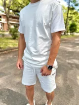 Conjunto deportivo blanco compuesto por una remera de manga corta de corte holgado y un short con cordón ajustable en la cintura.