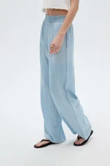 Pantalón celeste de lyocell, de corte ancho y tiro alto, con bolsillos laterales.