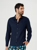 Camisa de manga larga en color gris, con cuello clásico, cierre frontal de botones y un bolsillo en el pecho.