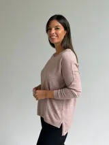 Sweater de punto fino en color rosa melange, con escote en V y mangas largas de corte holgado.