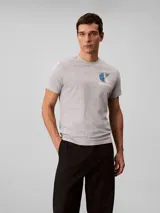 Remera gris melange de manga corta con cuello redondo, confeccionada en algodón regenerativo. Cuenta con un pequeño estampado gráfico del monograma y la inscripción de la marca en el pecho.