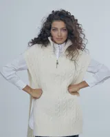 Chaleco largo de punto color crudo con diseño de trenzas, cuello alto con cierre de cremallera metálica y sisas amplias.