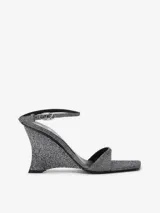 Sandalias de cuña Diesel D-Amber inspiradas en los años 90, con acabado brillante plateado, punta cuadrada abierta, diseño de dos tiras, tacón de cuña y tira ajustable al tobillo con hebilla ovalada con logo.
