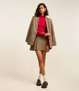 Suéter negro de punto con cuello alto, mangas largas abullonadas y puños largos.