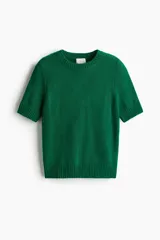 Buzo de punto suave con cuello redondo y mangas cortas. Presenta un diseño entallado con terminaciones acanaladas en cuello, puños y ruedo.