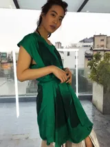 Vestido fucsia con estampado abstracto en tonos borgoña, corte midi, sin mangas, con escote en la espalda y lazo en la cintura.