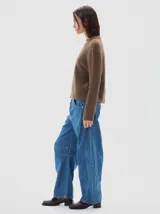 Polera de tejido de punto acanalado, con cuello subido y manga larga. Presenta un diseño al cuerpo con un pequeño bordado a tono en el frente.