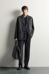 Blazer regular fit de color gris oscuro, confeccionado en tejido con estructura, con cuello de solapas de muesca, cierre frontal con botones y bolsillos plastrón con solapa en el delantero.