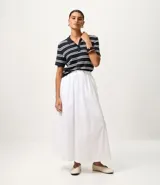 Blusa de punto de viscosa certificada, color azul marino con rayas horizontales blancas. Tiene mangas cortas y cuello polo con cierre de botones.