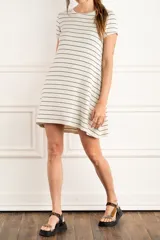 Vestido corto de lino color crudo con rayas horizontales negras, corte suelto, cuello redondo y mangas cortas.