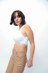 Top corto de morley color blanco, con escote redondo y elástico personalizado con el nombre de la marca en el bajo busto.